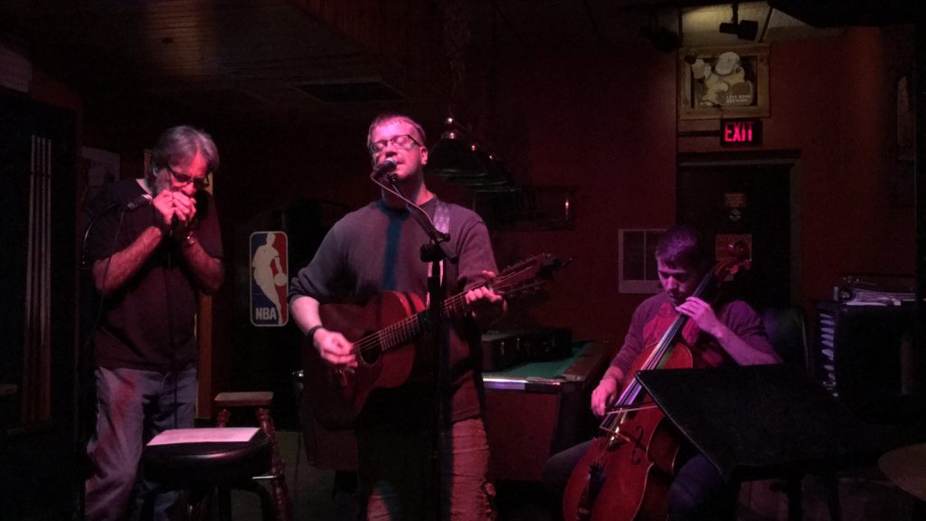 Jim Carlson performing with Duffy Duyfhuizen (harmonica) and Carter Clay (cello) at the Tomahawk Room, Chippewa Falls, WI